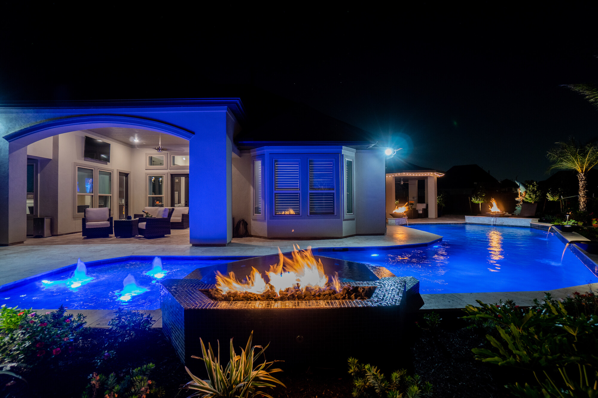 Outdoor Living - Houston - Pool and spa area lit up at night