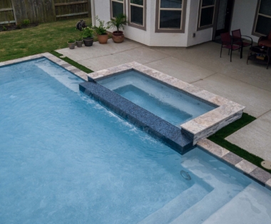 Spa fountain pours over into a pool
