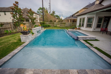 White stone fireplace and spa near a pool