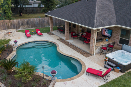 Red lounge chairs near bean shaped pool and hot tub