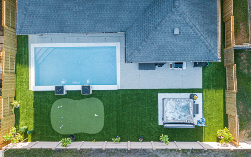 Putting green near a hot tub and pool