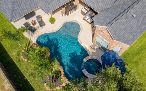 Aerial view of a pool, spa, and outdoor kitchen