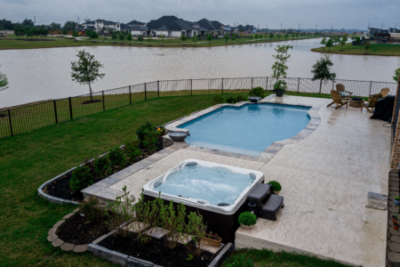 Hot tub and pool bordering a lake
