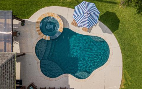 Overhead view of two day chairs, a hot tub, and a pool