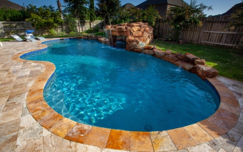 Tan lined bricks and rock formation around a pool