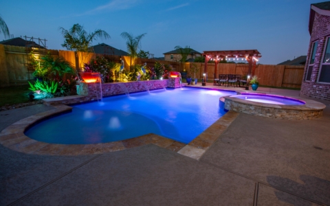 Glowing lights near a purple lit pool at night