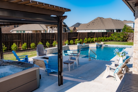 Outdoor lounge space and firepit near blue pool